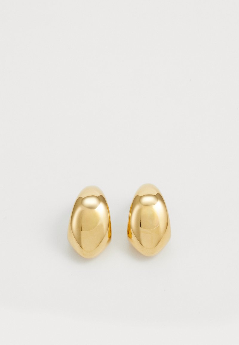 Gold metal stud earrings with a smooth, rounded, pebble-like design. Reflective surface enhances the metallic appearance.