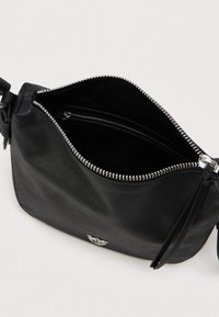 Μαύρη δερμάτινη τσάντα ώμου με ασημένιο φερμουάρ που είναι εν μέρει ανοιχτό, αποκαλύπτοντας την εσωτερική τσέπη με φερμουάρ και την λεία εσωτερική επένδυση.