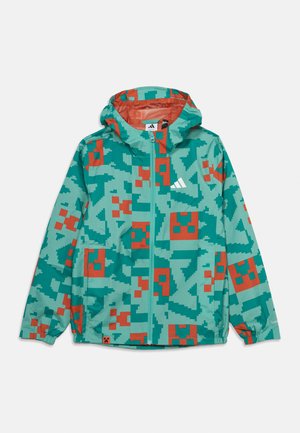 Kinderjas met capuchon met groen-oranje gepixeld patroon, rits aan de voorkant, elastische manchetten en een wit sportlogo op de borst.