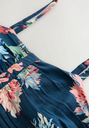 Tamsiai mėlynos medžiagos gėlių raštuota suknelė, puošta rožinėmis ir žaliomis gėlėmis, turi reguliuojamas petnešas ir suspaustą juosmens liniją, kad suteiktų pridedamų detalių.