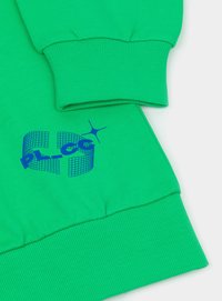 Zielona bluza z ribbowanymi mankietami, logo w wzór kratki oraz stylizowanym niebieskim napisem na dolnej krawędzi. Miękka tekstura i luźny krój.