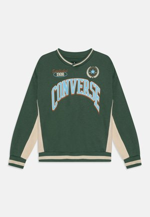 Felpa verde con il testo "CONVERSE" in bianco e arancione, dettagli beige sulle maniche, polsini e colletto a coste, e anno di fondazione 1908.