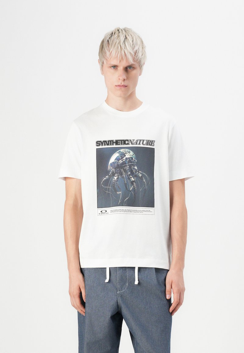White cotton t-shirt featuring a graphic design of a jellyfish against a dark background, with the text “SYNTH-ETIC NATURE” above it.