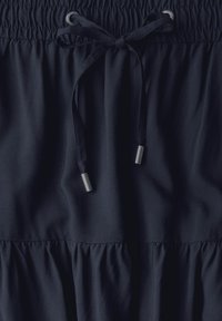 Gonna di tessuto blu navy con vita elastica, dotata di un cordoncino con punte metalliche e un design a strati con ruffle sull'orlo.