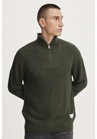 Donkergroen gebreid sweater met een halve ritssluiting bij de kraag, voorzien van een gestreept patroon op het lijfje en een klein label aan de zoom.