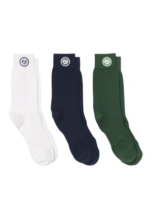Tre paia di calzini a metà polpaccio in bianco, blu navy e verde scuro con una toppa rotonda con il logo Roland Garros vicino alla parte superiore su sfondo bianco.