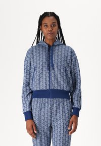 Felpa con zip blu a motivo, dotata di cappuccio con coulisse, polsini e orlo a costine, con un logo discreto. Realizzata in tessuto morbido con vestibilità comoda.