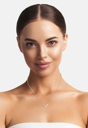 Halskette in Goldfarbe mit einem chevronförmigen Anhänger und einem filigranen Ausschnittdesign, der an einer zarten Kette hängt.