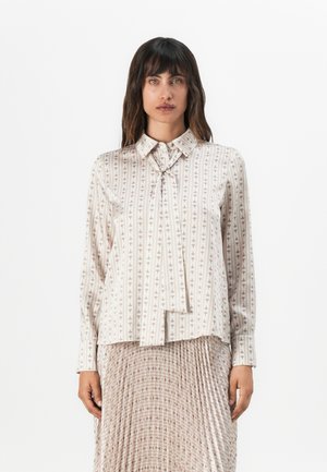 Langsleeve blouse van lichtgewicht stof; heeft een kraag, een strikdetail en een beige stof met verticale geometrische patronen.