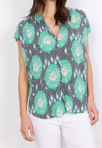 Krótki rękaw, szara bluzka z zielonymi kwiatowymi wzorami, posiadająca dekolt w kształcie litery V oraz lekką, gładką tkaninę. Idealna na codzienne wyjścia.