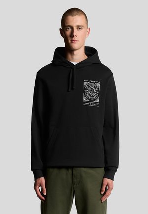 Svart hoodie med en framficka, snörning i huvan och vit grafisk design på bröstet som visar ett solmotiv och text. Mjuk tygtextur.