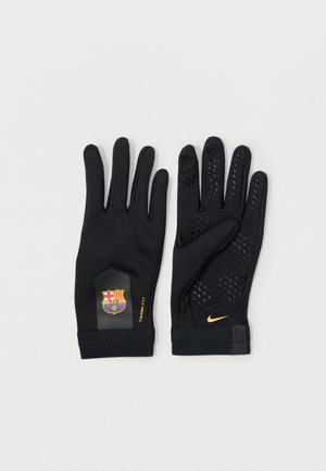 Gants de sport noirs avec grip texturé sur les paumes, portant un logo de Barcelone et une étiquette "THERMA-FIT". Swoosh de Nike en jaune sur le poignet.