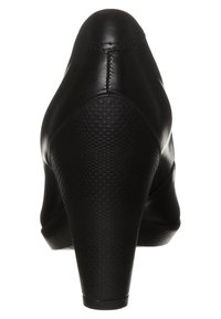 Chaussure à talon compensé en cuir noir avec un dos texturé et à motifs et une partie supérieure lisse, présentant un bout arrondi et une hauteur de talon modeste.