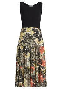 Svart ärmlös topp med en blommönstrad kjol som har gröna, orange och gula nyanser; volangkant och olika bladdesigns.