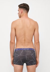 Black boxer briefs with a geometric white pattern and a blue waistband featuring “sloggi” branding, made from a stretch fabric for comfort.