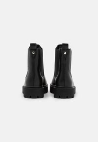 Black leather ankle boots with a smooth finish, featuring elastic side panels, pull tabs, and a chunky, textured sole.
