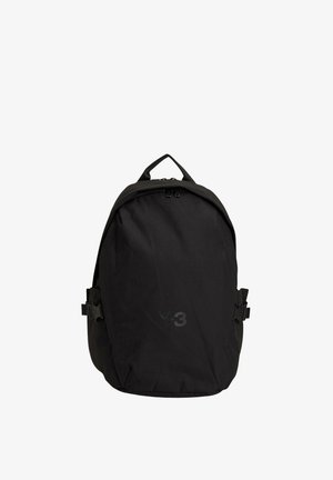 Zwarte rugzak gemaakt van duurzaam textiel, met een afgeronde vorm, bovenhandvat, verstelbare zijriemen en een subtiel logo aan de voorkant.