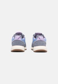Sneakers i ljusblå och grå mocka med lavendelaccenter, med en texturerad hälflik och en tjock vit gummisula.