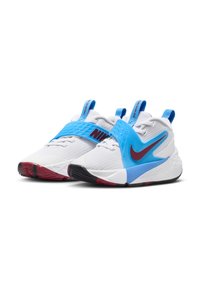 Les baskets Nike présentent un dessus en maille blanche avec une sangle bleue, des accents rouges et une semelle en caoutchouc texturée. Conception durable avec un branding marqué.
