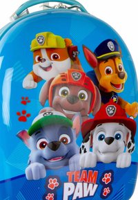 Mochila de concha dura con un fondo azul que presenta seis perros de dibujos animados. Detalles destacados: colores brillantes, expresiones juguetonas y huellas de patas.