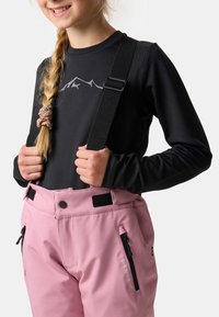 Czarna koszula z długim rękawem z nadrukiem górskim, zestawiona z różowymi spodniami narciarskimi z zamkniętymi kieszeniami i regulowanymi ramiączkami.