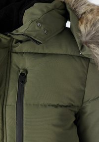 Grøn polstret jakke med lynlås og trykknapper, med hætte trimmet med pels og tekstureret stof.