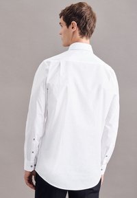 Witte overhemd met knopen van een gladde katoenen textuur, met lange mouwen, een klassieke kraag en zwarte knoopdetails bij de manchetten.