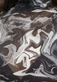 Durchsichtiges schwarzes und weißes Gewebe mit einem wirbelnden Marmor-Muster, das eine glatte Textur und einen sanften Fall aufweist und die visuelle Tiefe und den Kontrast verstärkt.