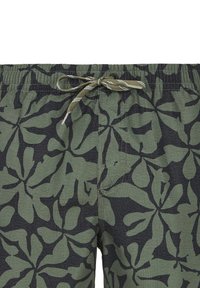 Zeleni i crni kupaćih šorts s uzorkom lišća, elastični pojas i vezica. Tekstura se čini rebrastom.