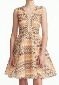 Abito corto aderente con scollatura a V e senza maniche, caratterizzato da un motivo zigzag multicolore in tessuto giallo, rosa e nero.