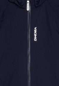 Chaqueta de color azul marino con cierre de cremallera, que presenta la palabra "VIKING" en blanco. El material parece ligero y tiene una textura suave.