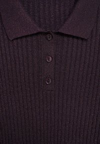 Dark purple polo shirt with ribbed texture, four buttons, and a classic collar; features subtle metallic threads for added detail.