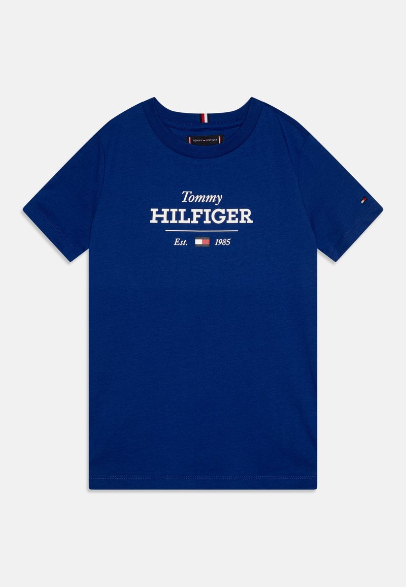 Blaues T-Shirt mit kurzen Ärmeln und Rundhalsausschnitt, bedruckt mit weißem "Tommy Hilfiger Est. 1985"-Text sowie kleinem rot-weiß-blauem Flaggenlogo auf der Brust und dem Ärmel.