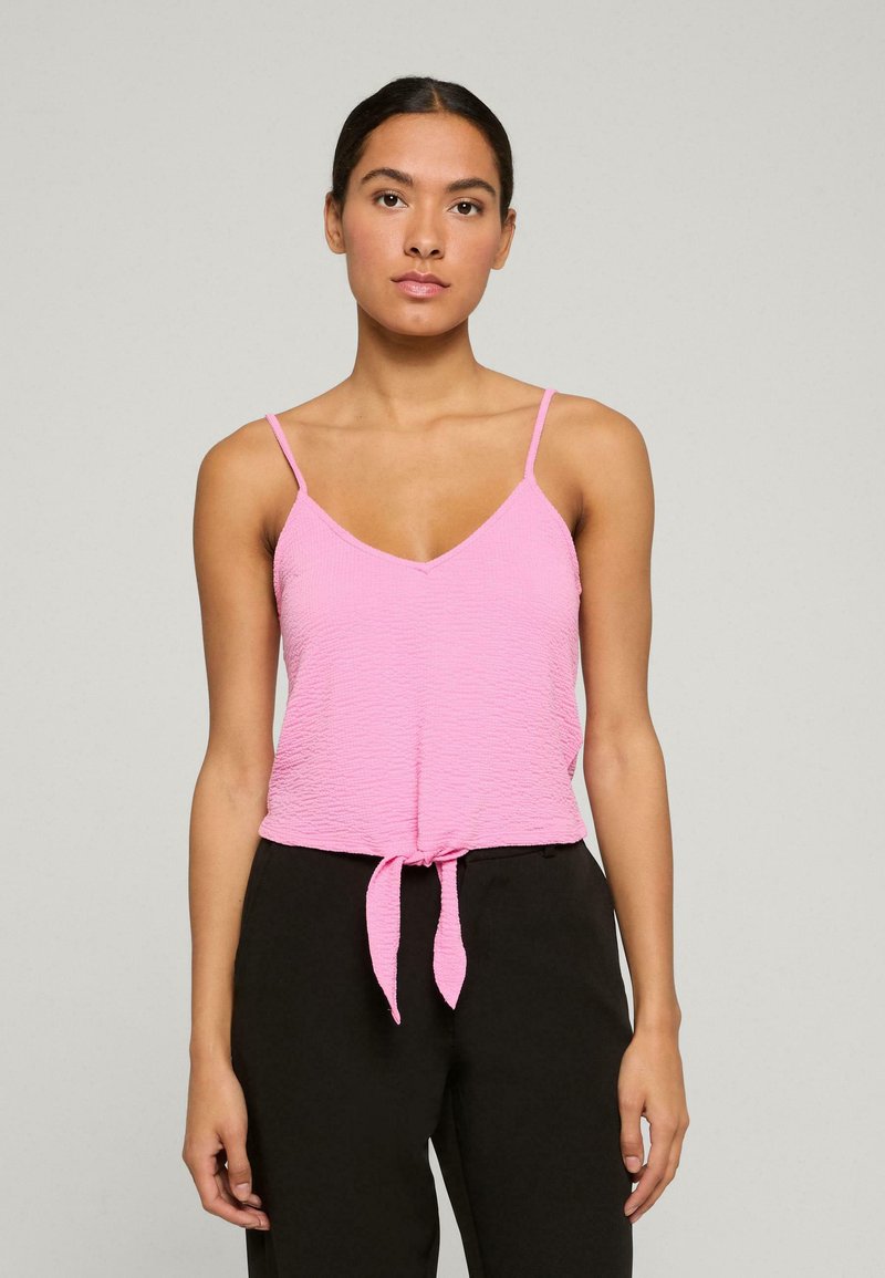 Roze mouwloze top van een textuurstof, met een V-hals en verstelbare spaghettibandjes. Heeft een geknoopte detail rond de taille.