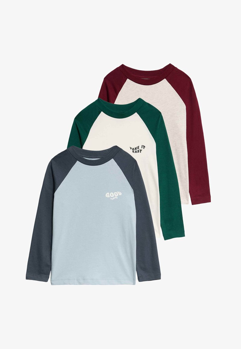 Drie langemouw t-shirts met raglanmouwen. Kleuren zijn lichtblauw, crème met groene accenten, kastanjebruin en donkergrijs. Bevat tekst.