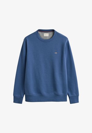 Hanorac bleu cu mâneci lungi, guler rotund, cu manșete și tiv elastic, având un mic logo GANT brodat pe partea stângă a pieptului.