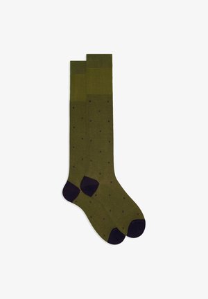 Tall socks in olive green, featuring a ribbed texture with navy polka dots and solid navy heel and toe accents.