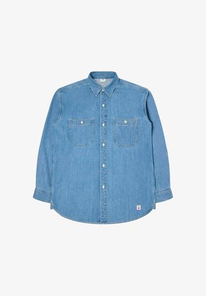 Camicia in denim azzurro chiaro a maniche lunghe con colletto button-down, due tasche sul petto e bottoni bianchi. Caratterizzata da un orlo curvo e dettagli di cucitura sottili.