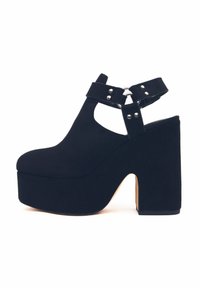 Scarpe con plateau nere in suede con tacco spesso, design con punta aperta, cinturino alla caviglia con anello di metallo e dettagli con borchie.