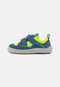 Basket bleu et néon jaune pour enfant avec deux sangles Velcro ajustables et une épaisse semelle grise sur fond blanc.