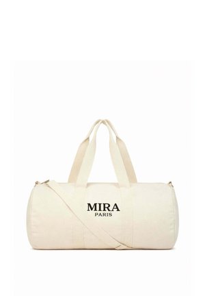 Roomkleurige cilindervormige duffeltas met dubbele handvatten aan de bovenkant, verstelbare schouderriem en "MIRA PARIS" in zwarte letters aan de voorkant.