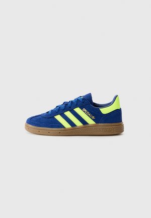 Baskets Adidas bleues avec des bandes jaune fluo et un patch au talon, semelle en gomme et marquage "Spezial" sur le côté.