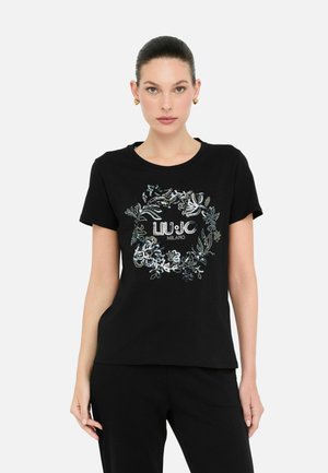 Schwarzes Baumwoll-T-Shirt mit gesticktem Blumenmuster in Silber und Weiß sowie dem Text "LIU JO MILANO" in der Mitte. Runder Halsausschnitt, kurze Ärmel.