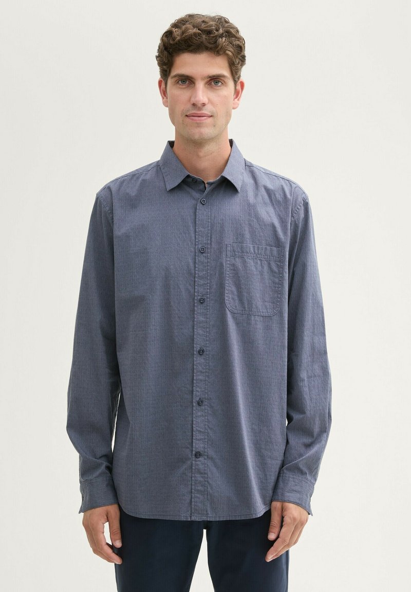 Langärmliges, dunkelblaues Button-up-Hemd mit subtiler Struktur, einer Brusttasche und einem klassischen Kragen, aus leichtem Stoff gefertigt.