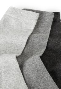 Tre paia di calzini: grigio chiaro, grigio medio e grigio scuro. Realizzati in tessuto morbido e testurizzato con un design a bordo rigato.