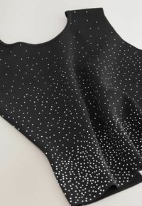 Musthall täiuseta top, millel on tekstuuriga ribatrepp, kaunistatud hajutatud valgete sukkadega, mis loob kontrastset mustrit üle kogu pinna.
