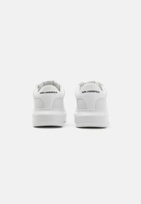 Hvite lær sneakers med en jevn tekstur, med merkevare på hælen og et minimalistisk design. Gummisåler med en liten plattform.