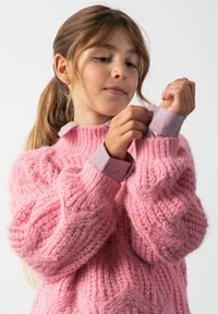 Różowy sweter z dzianiny o fakturowanym wzorze i oversize'owych rękawach. Ma jasnofioletowy kołnierz i mankiety, co dodaje kontrastu do wzoru.