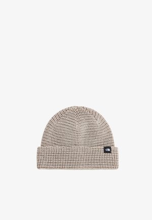 Beżowa dziana czapka z odwiniętym brzegiem, z małą czarno-białą naszywką z logo The North Face na brzegu.