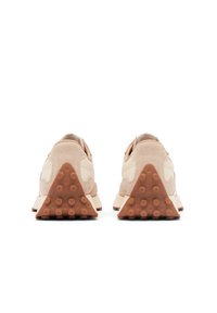 Béžové nubukové tenisky s trojúhelníkovou, texturovanou hnědou podrážkou. Mají hladký design svršku a minimální branding na patě.
